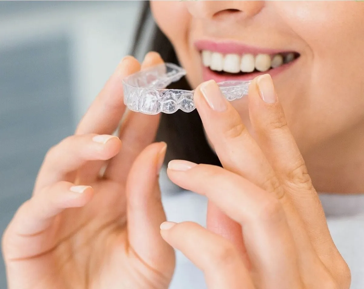 Paciente sosteniendo un alineador transparente